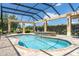 Relaxing screened-in pool with a spa, waterfall feature, outdoor grill, and comfortable lounge chairs at 3319 Barrington Ct, The Villages, FL 32162