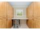 Large storage room featuring custom cabinets, a built-in desk, and a sleek beverage refrigerator at 3319 Barrington Ct, The Villages, FL 32162