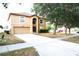 Two-story home with a two-car garage, large front lawn, and mature trees at 3329 White Blossom Ln, Clermont, FL 34711