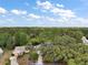 Aerial view of a house with a blue outline with surrounding trees and a pond at 34 Gordon Ct, Leesburg, FL 34788