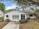 Inviting single-story home features a screened entry and mature landscaping at 34 Gordon Ct, Leesburg, FL 34788