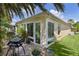 Outdoor patio with grill, adjacent to a sunroom and landscaped yard at 3433 Nestlebranch Ave, The Villages, FL 32163