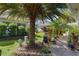 Landscaped backyard featuring a palm tree, patio area, and lush greenery at 3433 Nestlebranch Ave, The Villages, FL 32163