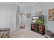 Cozy bedroom with carpet, television, closet, and doorway to hallway and decorated in pleasing neutral tones at 3433 Nestlebranch Ave, The Villages, FL 32163