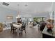 Open-concept dining room flows into living room and kitchen, features hardwood flooring, stylish pendant lighting and modern decor at 3433 Nestlebranch Ave, The Villages, FL 32163