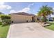 Attractive home with a well-kept lawn, pineapple driveway accent, and two-car garage at 3433 Nestlebranch Ave, The Villages, FL 32163