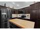 Modern kitchen features stainless steel appliances, a butcher block island and ample cabinet space at 3433 Nestlebranch Ave, The Villages, FL 32163