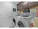 Functional laundry room with washer, dryer, storage cabinets and wire shelving at 3433 Nestlebranch Ave, The Villages, FL 32163