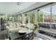 Bright sunroom with large windows offering lush backyard views and comfortable seating at 3433 Nestlebranch Ave, The Villages, FL 32163