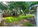 Lush backyard with mature trees, green grass, and a privacy fence at 35107 Sweet Leaf Ln, Leesburg, FL 34788