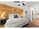 Bedroom showcasing a wood accent wall, ceiling fan, bedside tables, and access to a walk-in closet at 35107 Sweet Leaf Ln, Leesburg, FL 34788