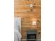 Close up view of a bedroom wood accent wall, bedside table, and lighting at 35107 Sweet Leaf Ln, Leesburg, FL 34788