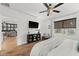 View of a bedroom featuring an open floor plan, accent wall, TV and access to living area at 35107 Sweet Leaf Ln, Leesburg, FL 34788