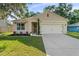 Attractive single-Gathering home featuring a lush lawn and an attached two-car garage at 35107 Sweet Leaf Ln, Leesburg, FL 34788