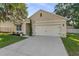 Beautifully designed house with a landscaped yard, a neutral color palette, and a two-car garage at 35107 Sweet Leaf Ln, Leesburg, FL 34788