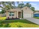 Inviting single-story house showcasing a neatly maintained front yard and a two-car garage at 35107 Sweet Leaf Ln, Leesburg, FL 34788