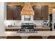Kitchen area with a wooden range hood, sink, and stainless steel appliances at 35107 Sweet Leaf Ln, Leesburg, FL 34788