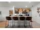 Modern kitchen featuring an island with seating, stainless steel appliances, and a wooden accent wall at 35107 Sweet Leaf Ln, Leesburg, FL 34788
