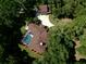Aerial view of a house with a screened pool, detached garage and landscaped yard surrounded by trees at 35350 County Road 439, Eustis, FL 32726