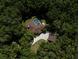 Aerial view of a house with a screened-in pool, detached garage, landscaped yard, and wooded area at 35350 County Road 439, Eustis, FL 32726