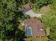Aerial view of a house with a screened-in pool and a detached garage surrounded by lush greenery at 35350 County Road 439, Eustis, FL 32726