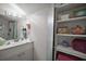 Clean bathroom with white vanity, mirror, and decorative shelving showcasing towels and personal care items at 35350 County Road 439, Eustis, FL 32726