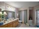 Bathroom featuring a vanity with double sinks, neutral wallpaper, and shower/tub combination at 35350 County Road 439, Eustis, FL 32726