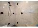 Close up of a modern walk-in shower featuring marble-look tile and black accent tile at 35350 County Road 439, Eustis, FL 32726