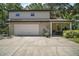 View of a home exterior with a garage, covered area with table, and well-maintained landscaping at 35350 County Road 439, Eustis, FL 32726