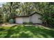 Exterior shot of a detached garage with a well-maintained lawn and surrounding trees at 35350 County Road 439, Eustis, FL 32726