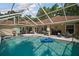 A sparkling pool is surrounded by a screened enclosure, patio, and lush landscaping, creating a private oasis at 35350 County Road 439, Eustis, FL 32726