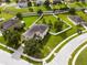 Aerial view of a well-maintained home featuring a manicured lawn, mature trees, and a white fence at 356 Giovani Blvd, Clermont, FL 34715