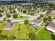 Aerial view of a well-maintained home featuring a swimming pool, mature trees, and a manicured lawn at 356 Giovani Blvd, Clermont, FL 34715
