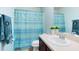 This is a bathroom with a tub shower combination with blue and white shower curtain and a vanity at 356 Giovani Blvd, Clermont, FL 34715