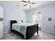 This bedroom features a ceiling fan, light blue walls, grey wood floors and an ensuite bathroom at 356 Giovani Blvd, Clermont, FL 34715