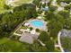 Aerial view of the community pool, featuring a spacious pool, lounge chairs, covered seating, and landscaping at 356 Giovani Blvd, Clermont, FL 34715