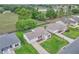 Aerial view of a well-maintained home, lush landscaping, and a community view with golf course and pond at 3590 Auburndale Ave, The Villages, FL 32162