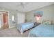 Bedroom with twin beds, ceiling fan, and a view into the bathroom at 3590 Auburndale Ave, The Villages, FL 32162