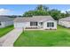 Charming single-story home with a well-maintained lawn and an attached garage, perfect for suburban living at 3590 Auburndale Ave, The Villages, FL 32162