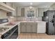 Traditional kitchen features a gas range, stainless steel sink, ample countertop space, and black refrigerator at 3590 Auburndale Ave, The Villages, FL 32162
