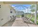 Enclosed lanai with outdoor seating and a view of the backyard and neighborhood at 3590 Auburndale Ave, The Villages, FL 32162