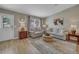 Comfortable living room featuring hardwood floors, neutral paint, comfortable seating, and natural light from windows at 3590 Auburndale Ave, The Villages, FL 32162
