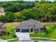A wide aerial view of a manicured property, showcasing a well-maintained lawn, a two-car garage, and privacy fencing at 3733 Statham Dr, Apopka, FL 32712