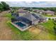 This backyard pool features a screen enclosure, solar panels and lush green grass at 3733 Statham Dr, Apopka, FL 32712