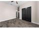 A stylish bedroom with wood-look tile flooring and black closet doors at 3733 Statham Dr, Apopka, FL 32712