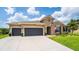 Charming single-story home with a two-car garage, lush green lawn, and manicured landscaping at 3733 Statham Dr, Apopka, FL 32712