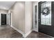 A well-lit hallway featuring hard surface floors and an ornate front door at 3733 Statham Dr, Apopka, FL 32712
