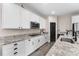 Kitchen with sleek white cabinets, granite countertops, stainless steel appliances, and modern wood-look tile flooring at 3733 Statham Dr, Apopka, FL 32712