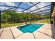 Sparkling pool in screened enclosure with patio and views of the lawn at 3733 Statham Dr, Apopka, FL 32712