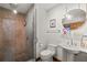 Modern bathroom with a stone shower, pedestal sink, large mirror, and tiled floor at 421 W 10Th Ave, Mount Dora, FL 32757